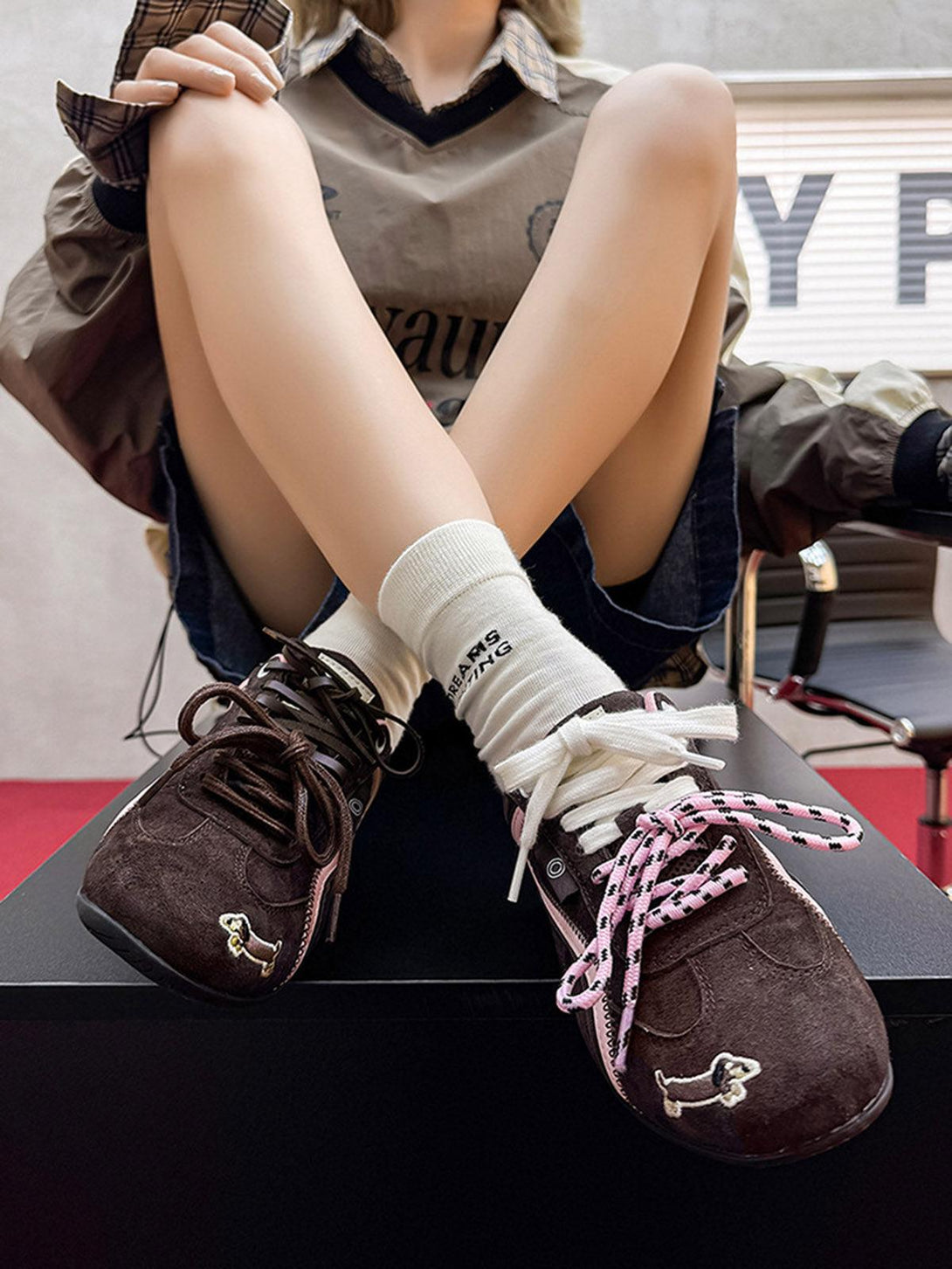 TALISHKO suede lace-up sneakers with playful dog embroidery and contrasting laces on a model.