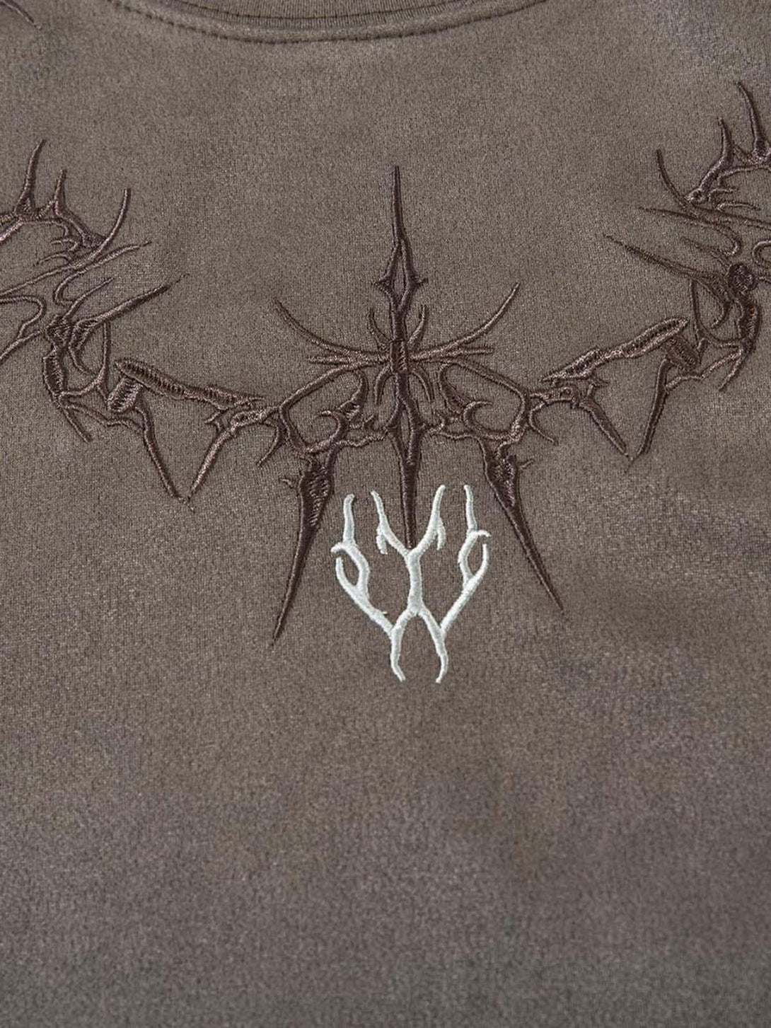 Intricate thorn embroidery on a suede vest by TALISHKO, highlighting detailed craftsmanship.