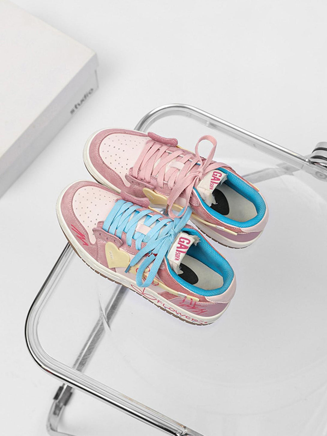 TALISHKO skate shoes with pink and blue laces, showcasing a playful design on a clear chair.