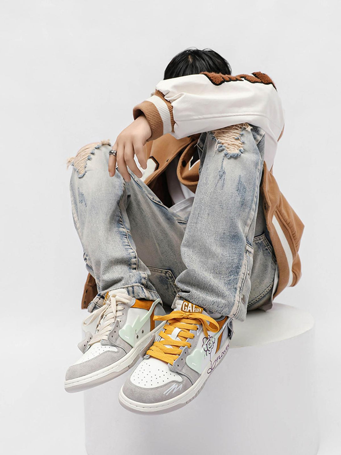 TALISHKO skate shoes with yellow laces and sunflower design, styled with ripped jeans.