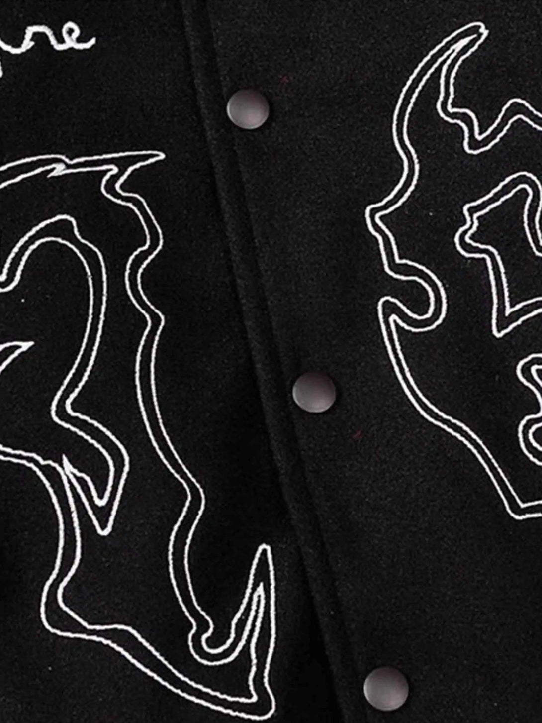 Intricate look at symbolic embroidery on TALISHKO's black racing jacket, highlighting unique design.