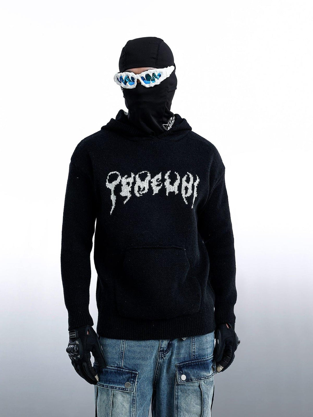 Model wearing a black TALISHKO sweater hoodie with a distinctive jacquard pattern and unique eyewear.