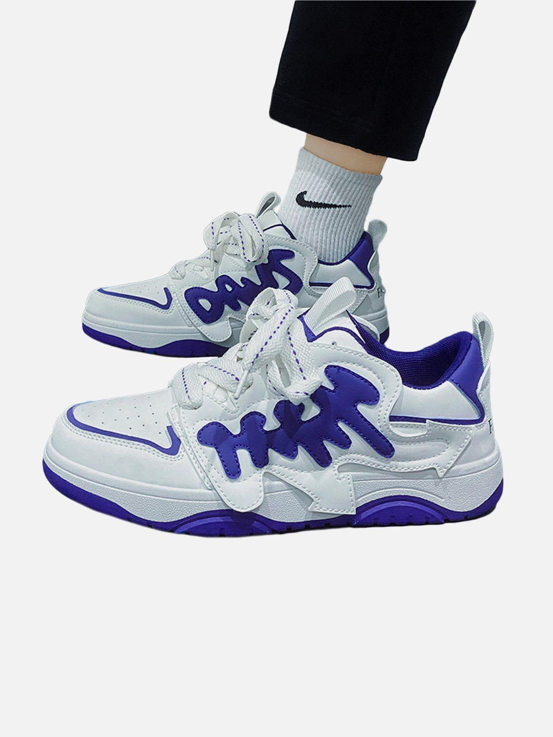 TALISHKO skate shoes with white and blue arrow design, styled for a bold urban look.