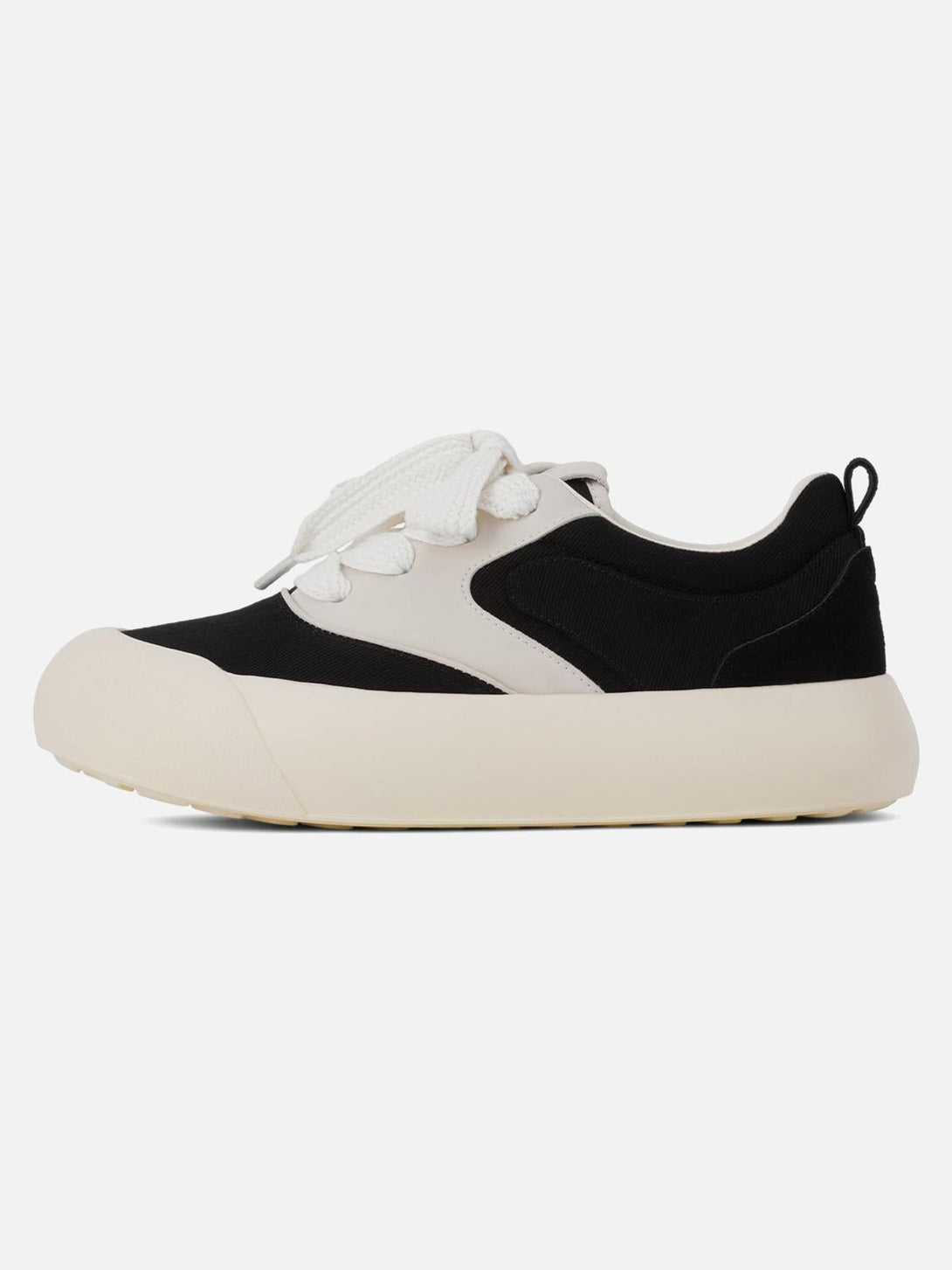 Side view of TALISHKO's chunky sneakers in a black and cream color-block design.