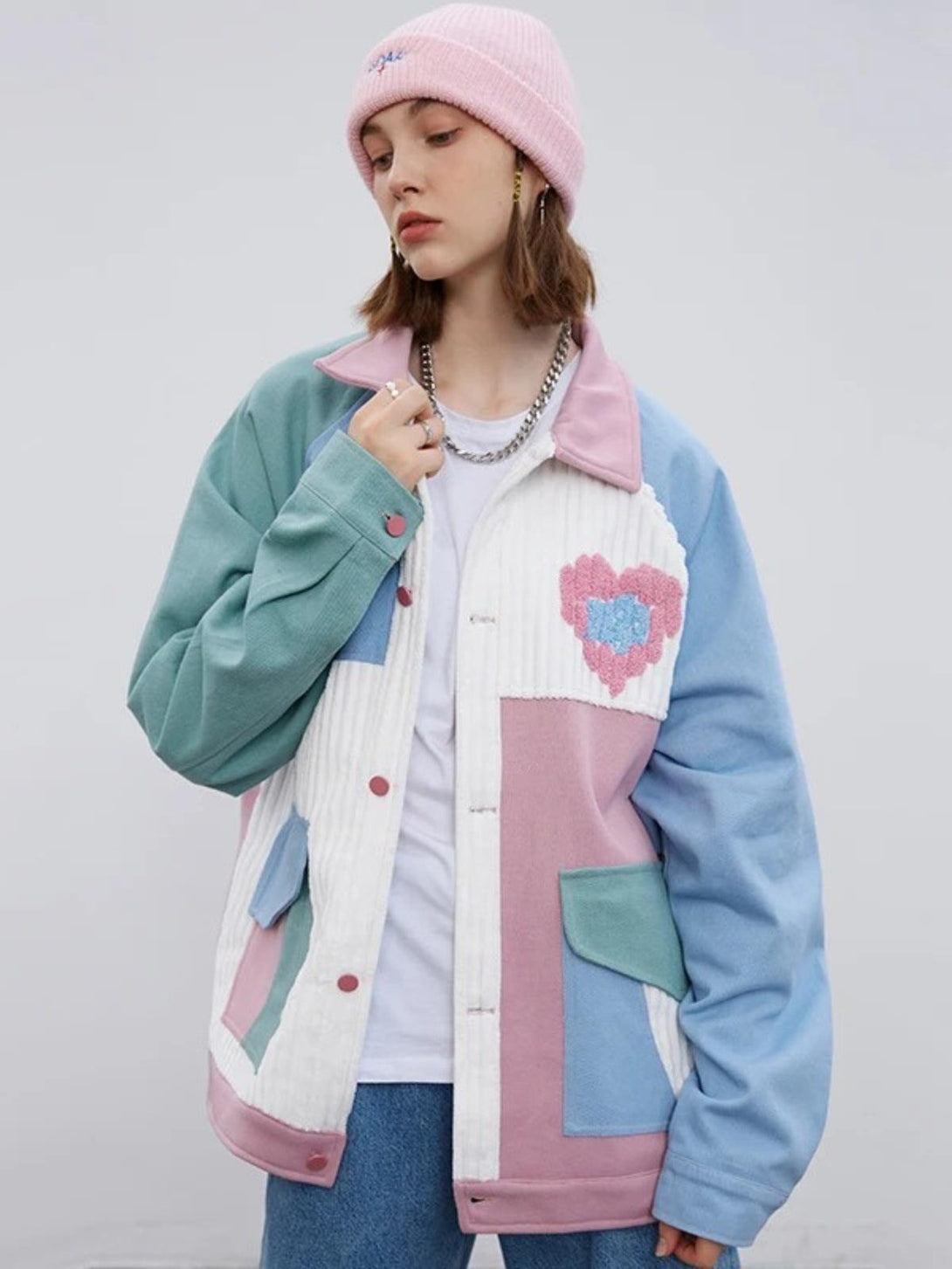 Model wearing a TALISHKO color block patchwork heart jacket in pastels, showcasing urban style.