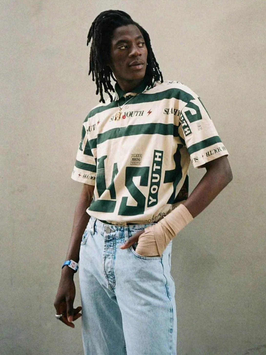 Model wearing khaki contrast polo shirt by TALISHKO, featuring bold graphic design in a casual style.
