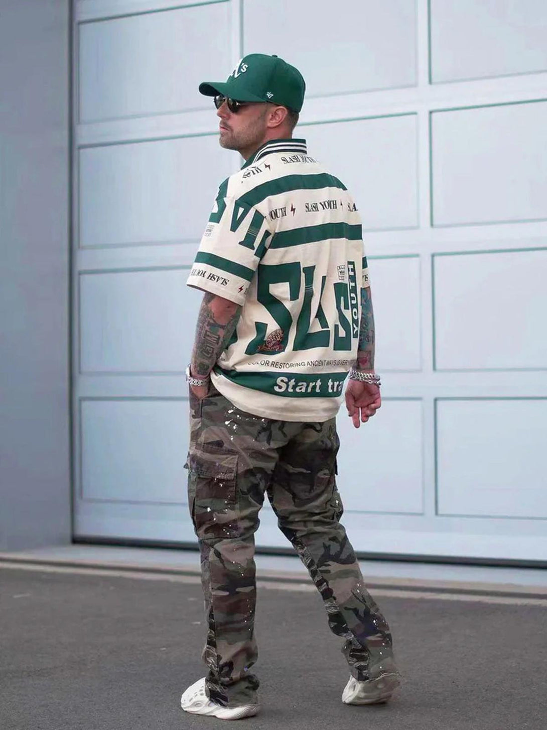 Model in khaki contrast polo shirt by TALISHKO, paired with camo pants for urban style.