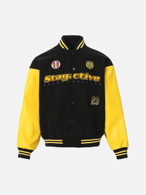 Front view of a black and yellow bomber jacket by TALISHKO featuring bold embroidery.