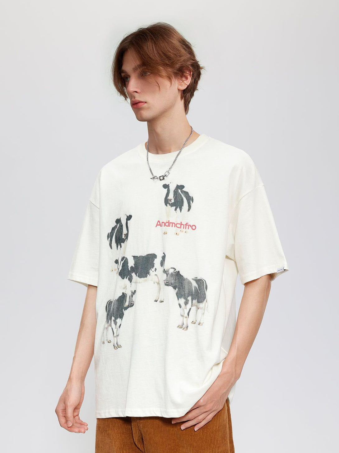 Model wearing a white cow print cotton tee by TALISHKO, showcasing a relaxed, casual style.