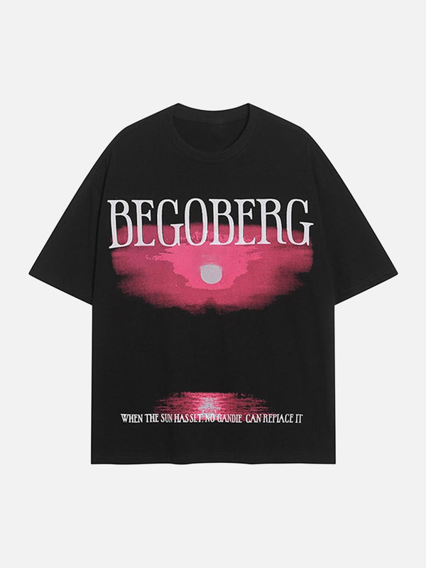 Front view of a black T-shirt by TALISHKO with a pink sunset ocean print and bold lettering.