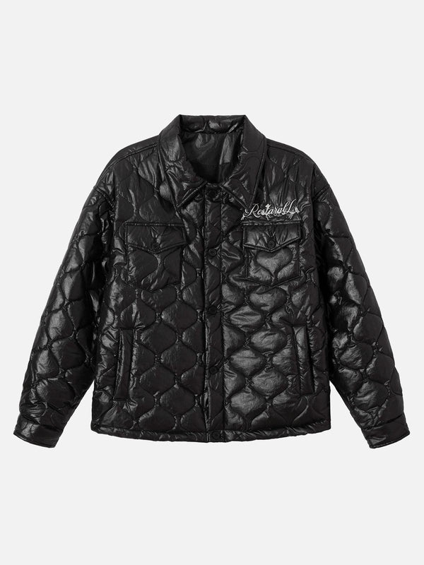 Front view of a black diamond-quilted jacket by TALISHKO, featuring letter embroidery detail.