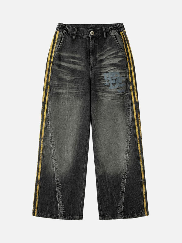 Front view of black TALISHKO jeans with yellow side stripes and patchwork detailing.
