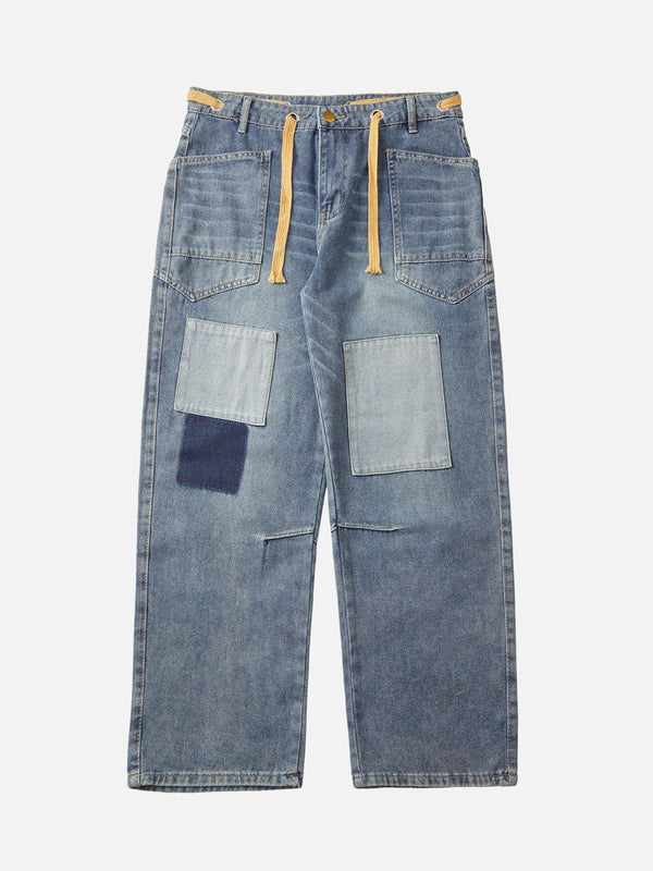 TALISHKO blue denim jeans with patchwork and drawstring detail, showcasing a front view.