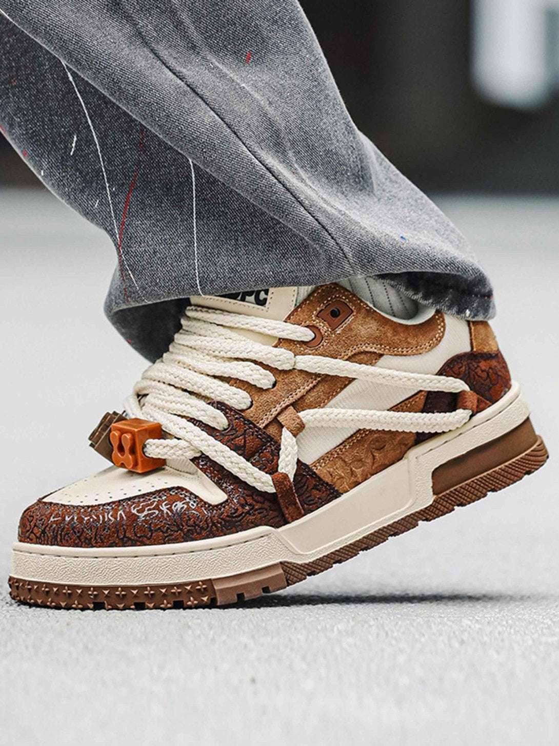 A close-up of brown TALISHKO sneakers with intricate details, perfect for casual street style.