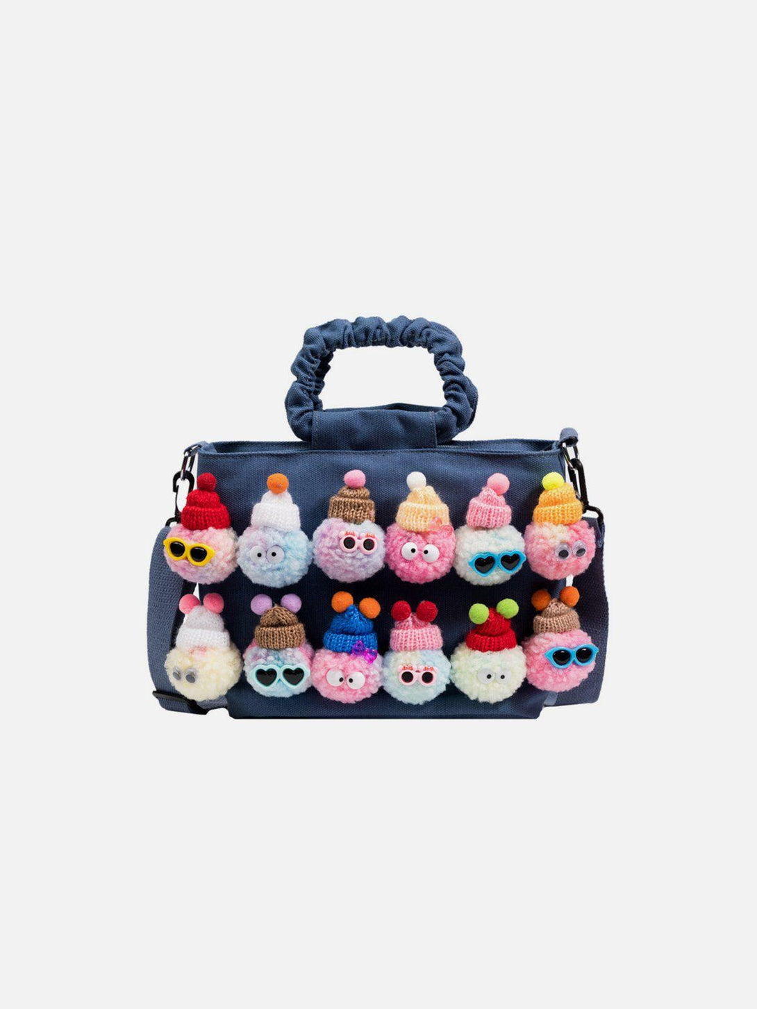 Front view of TALISHKO's dark blue canvas bag with whimsical pom-pom characters.