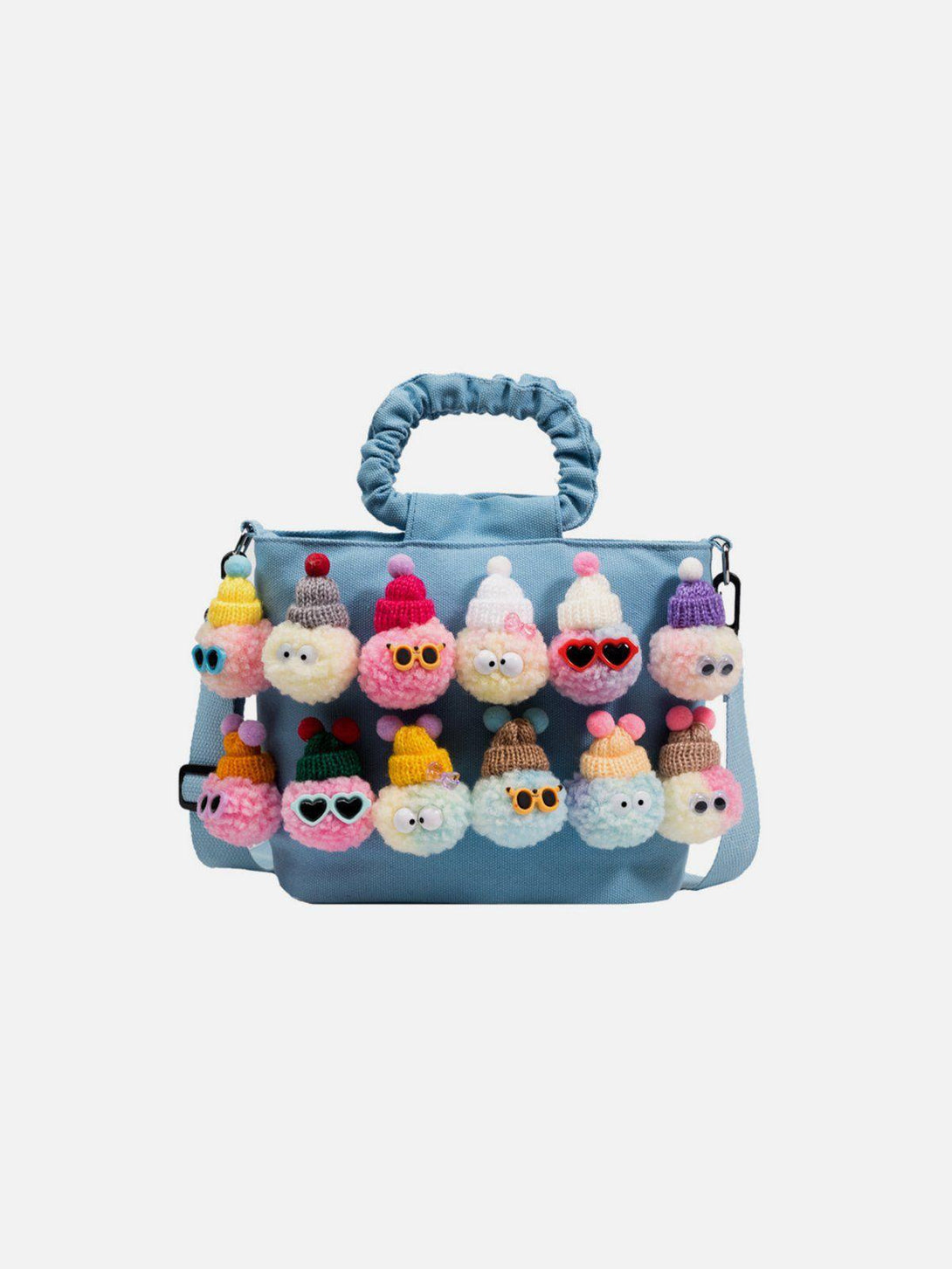 Front view of TALISHKO's light blue canvas bag adorned with playful pom-pom characters.