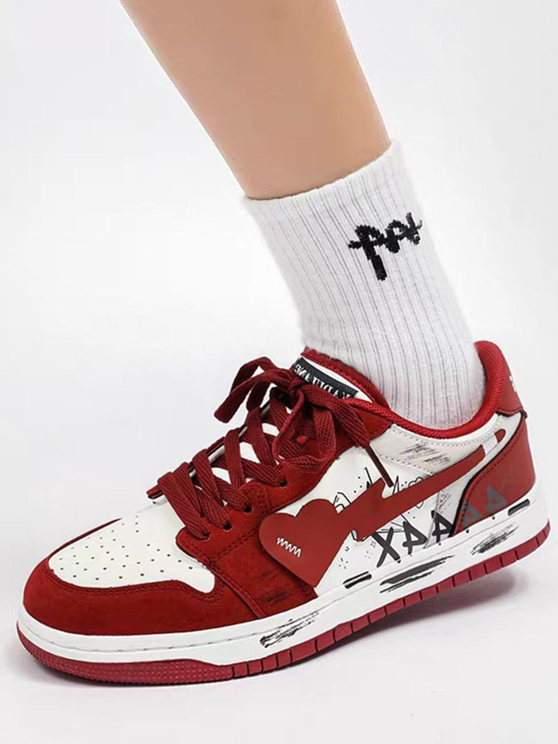 Front view of red and white skate shoes by TALISHKO, featuring graffiti and heart details.