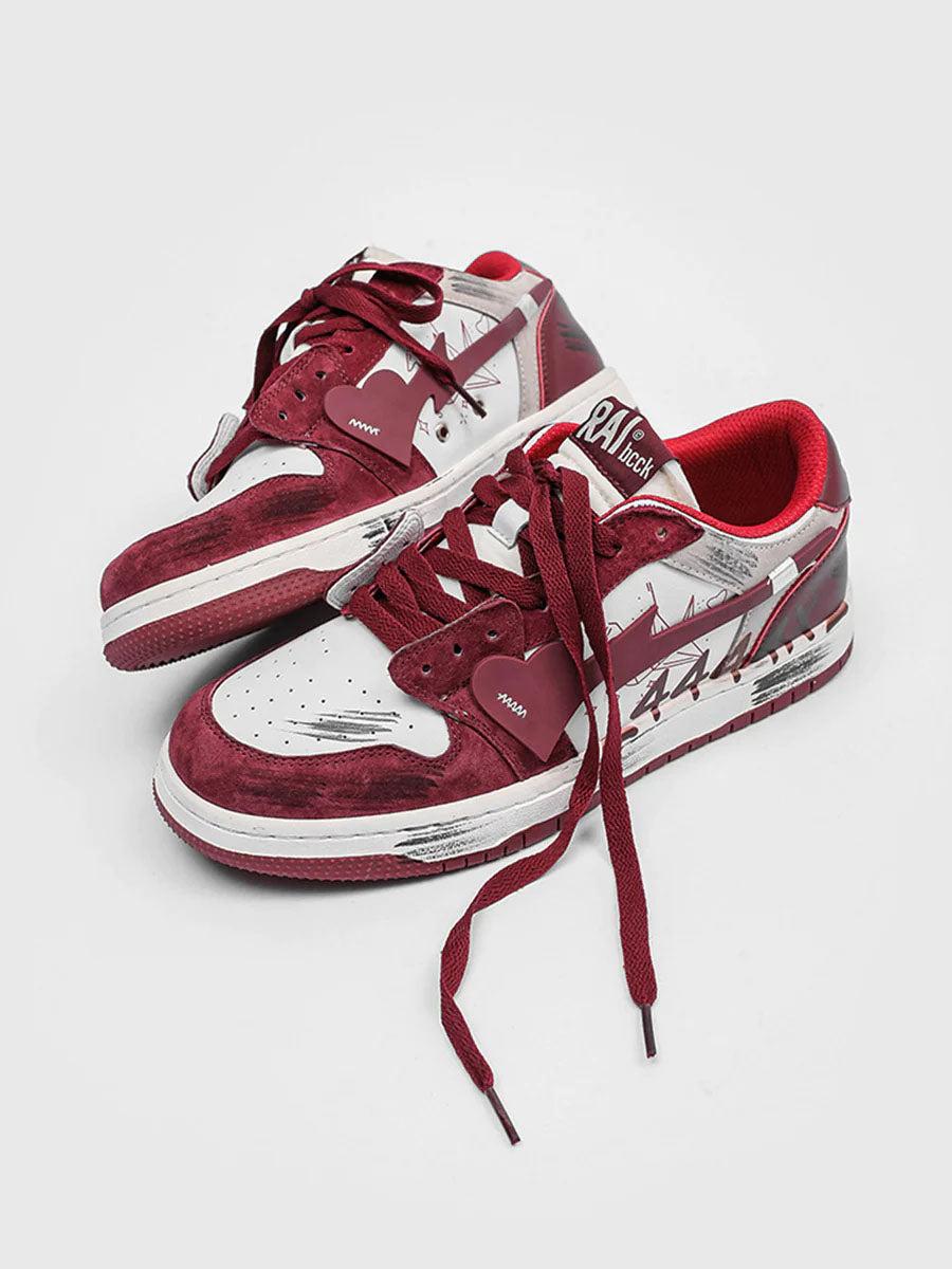 Front view of TALISHKO graffiti skate shoes in red and white, featuring bold, artistic design.