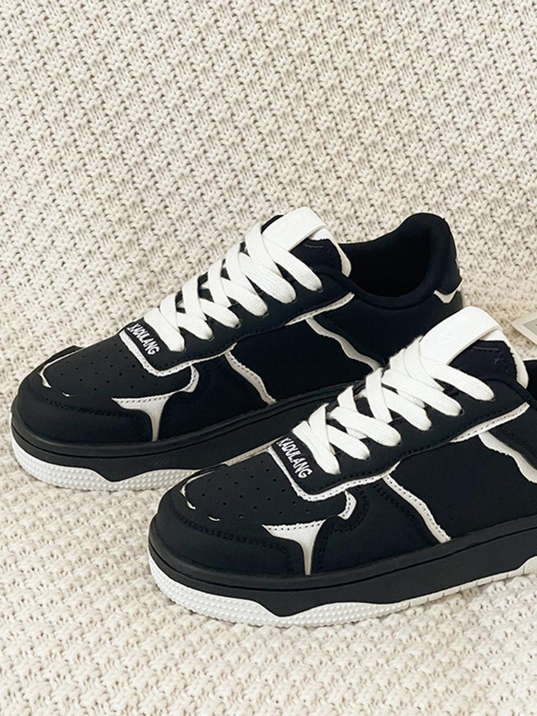 Front view of TALISHKO's black and white casual shoes, featuring stylish design and bold laces.