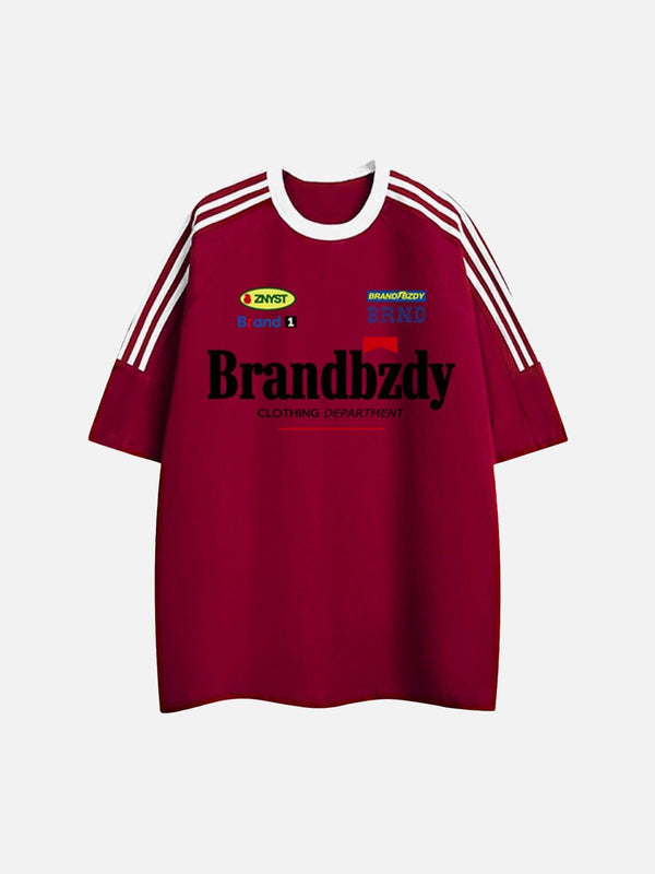 Front view of TALISHKO red jersey T-shirt featuring bold retro badges and sporty stripes.