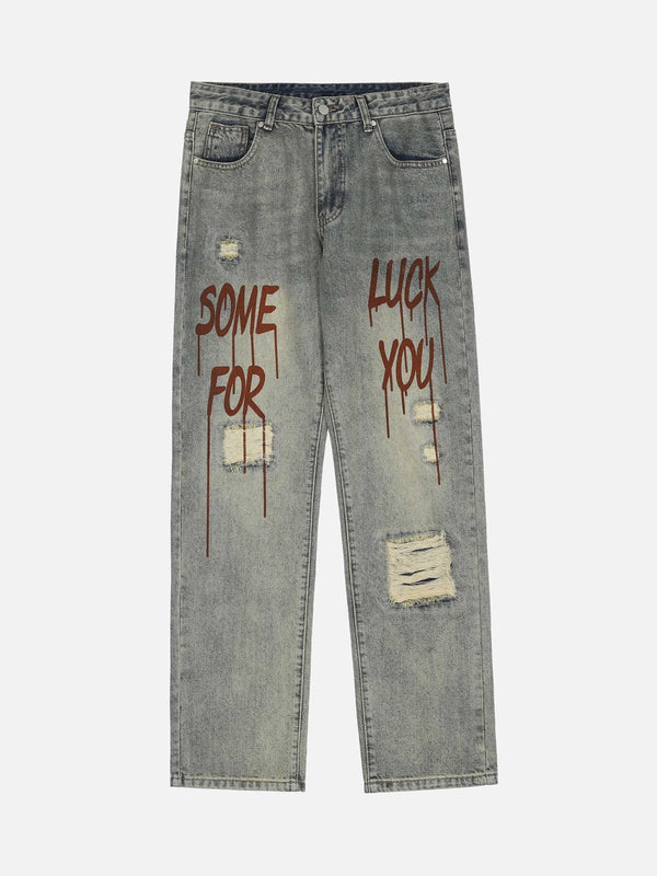 Front view of blue denim jeans with patches and bold text, by TALISHKO.