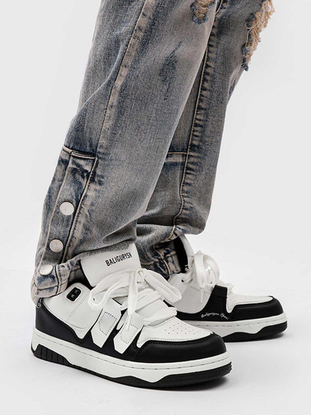 TALISHKO black and white board shoes styled with distressed jeans for a trendy urban look.