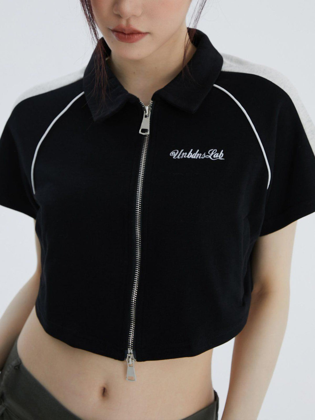 Front view of a black lapel zipper colorblock tee by TALISHKO, perfect for warm weather style.