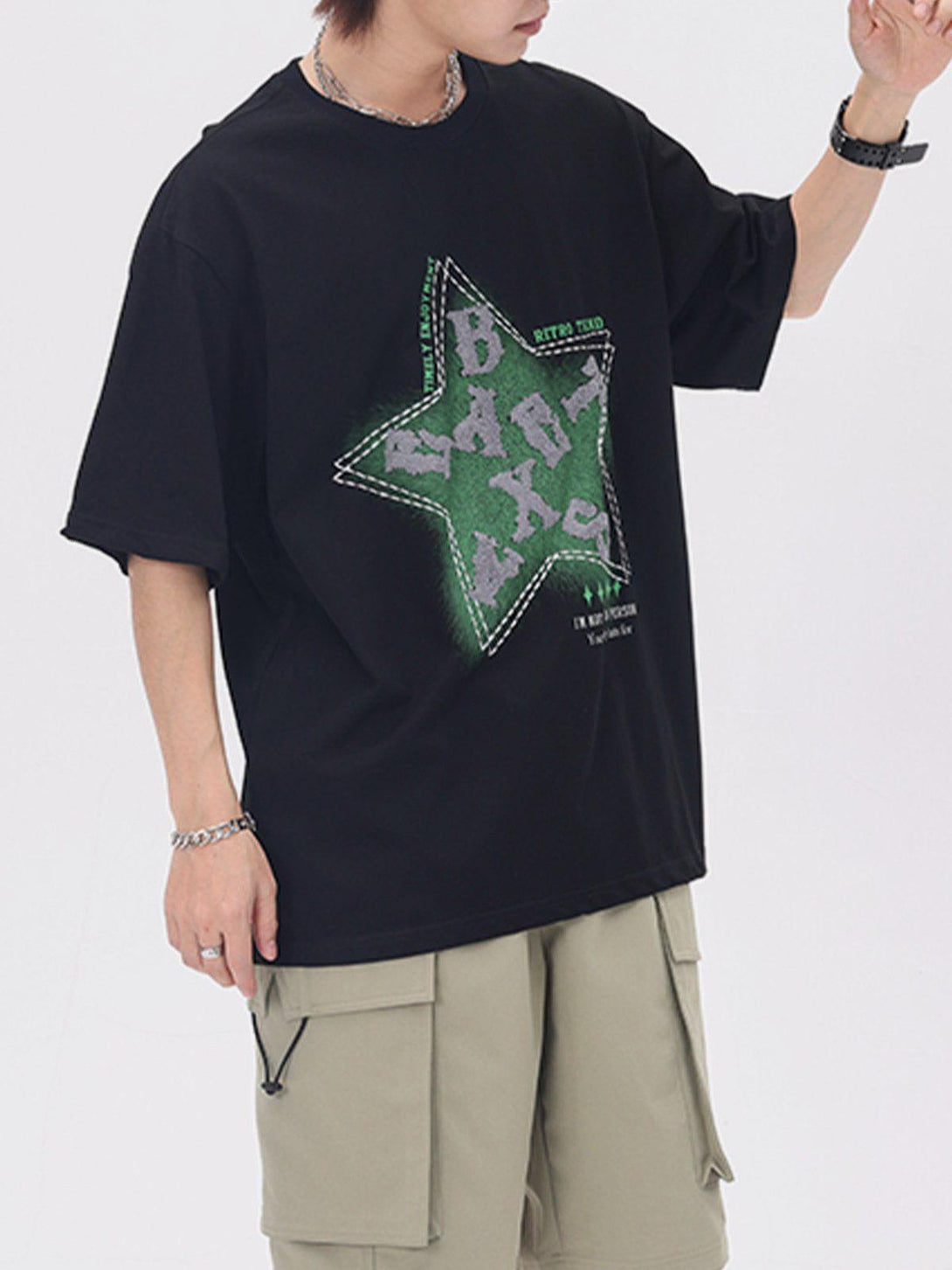 Model wearing a black TALISHKO tee with a star and letter design, paired with beige cargo shorts.