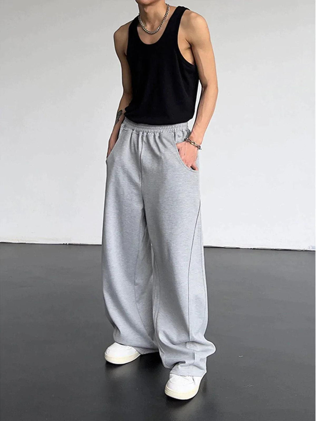Model in gray loose high waist pants by TALISHKO, capturing a laid-back, urban look.