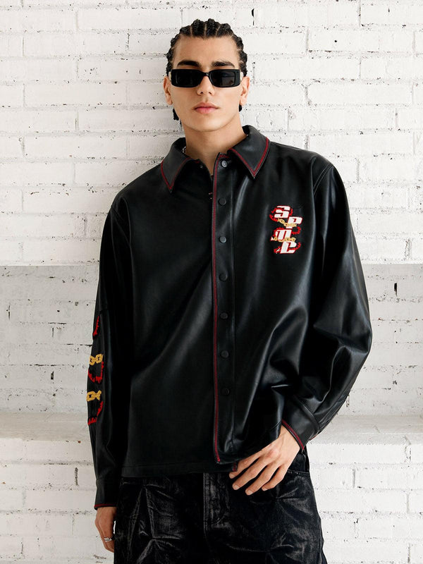 Model wearing a black leather shirt by TALISHKO, featuring bold embroidery and modern street style.