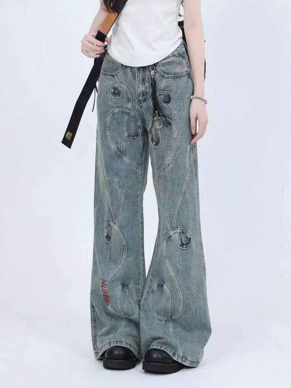 Model wearing blue jeans with intricate stitching, showcasing a relaxed fit by TALISHKO.