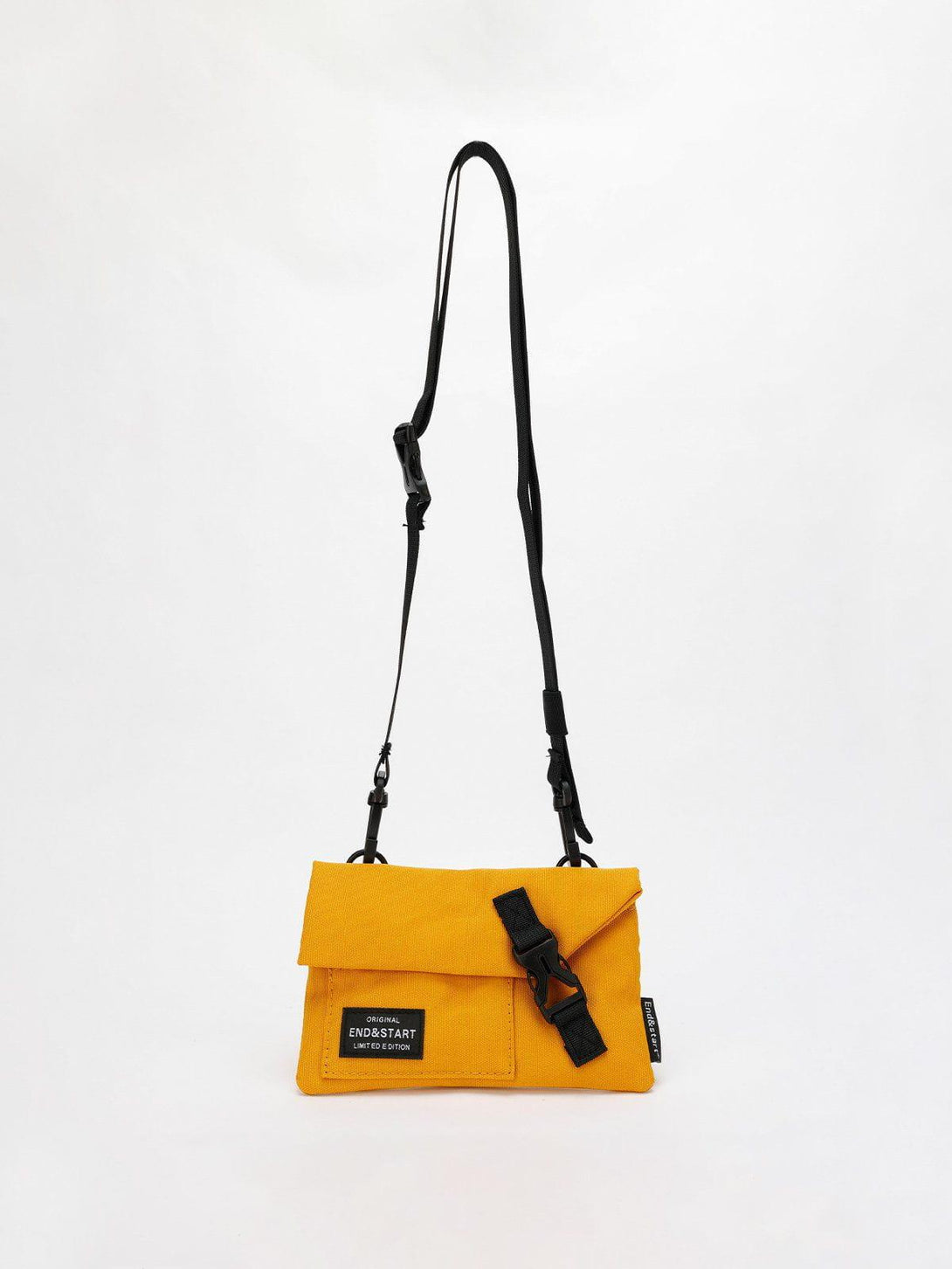 Yellow portable mini crossbody bag by TALISHKO with black strap and buckle, front view.