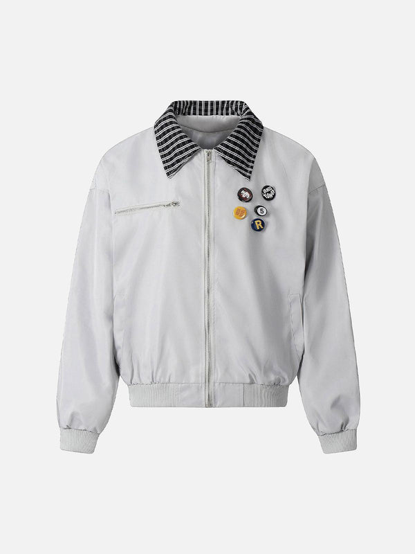 Front view of a gray retro jacket by TALISHKO, featuring badges and a striped collar.