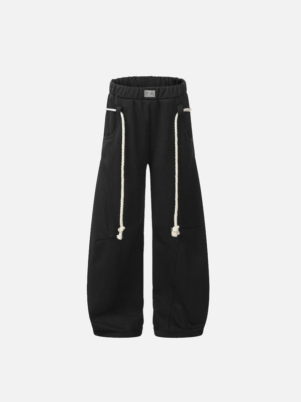 Front view of black retro curved drape sweatpants by TALISHKO with rope drawstrings.