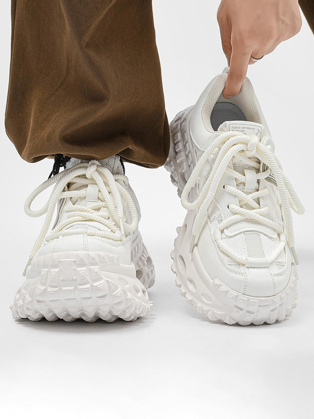 TALISHKO white chunky sneakers with tire sole detail, front view in casual street style.