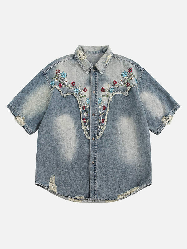 Front view of blue denim shirt by TALISHKO, featuring floral embroidery and distressed details.