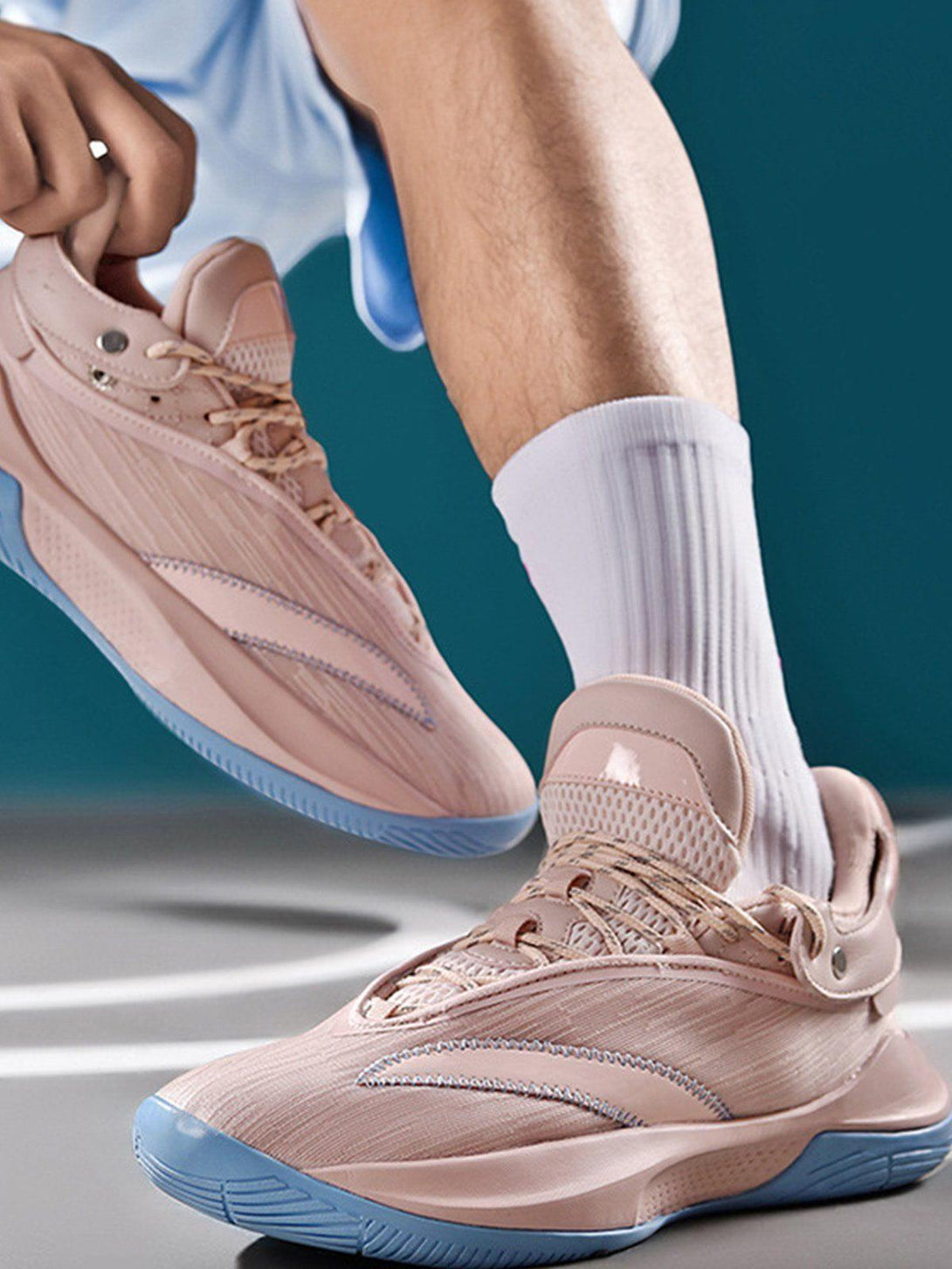 TALISHKO pink sneakers with blue soles, worn in an active setting, highlighting sleek design.