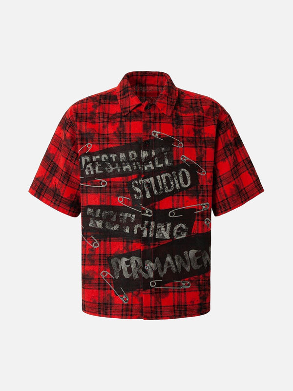 Red plaid shirt with bold graphic text and safety pin accents, front view by TALISHKO.