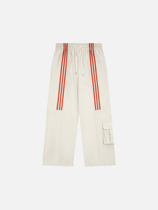 Front view of beige striped draped sweatpants by TALISHKO with red accents.