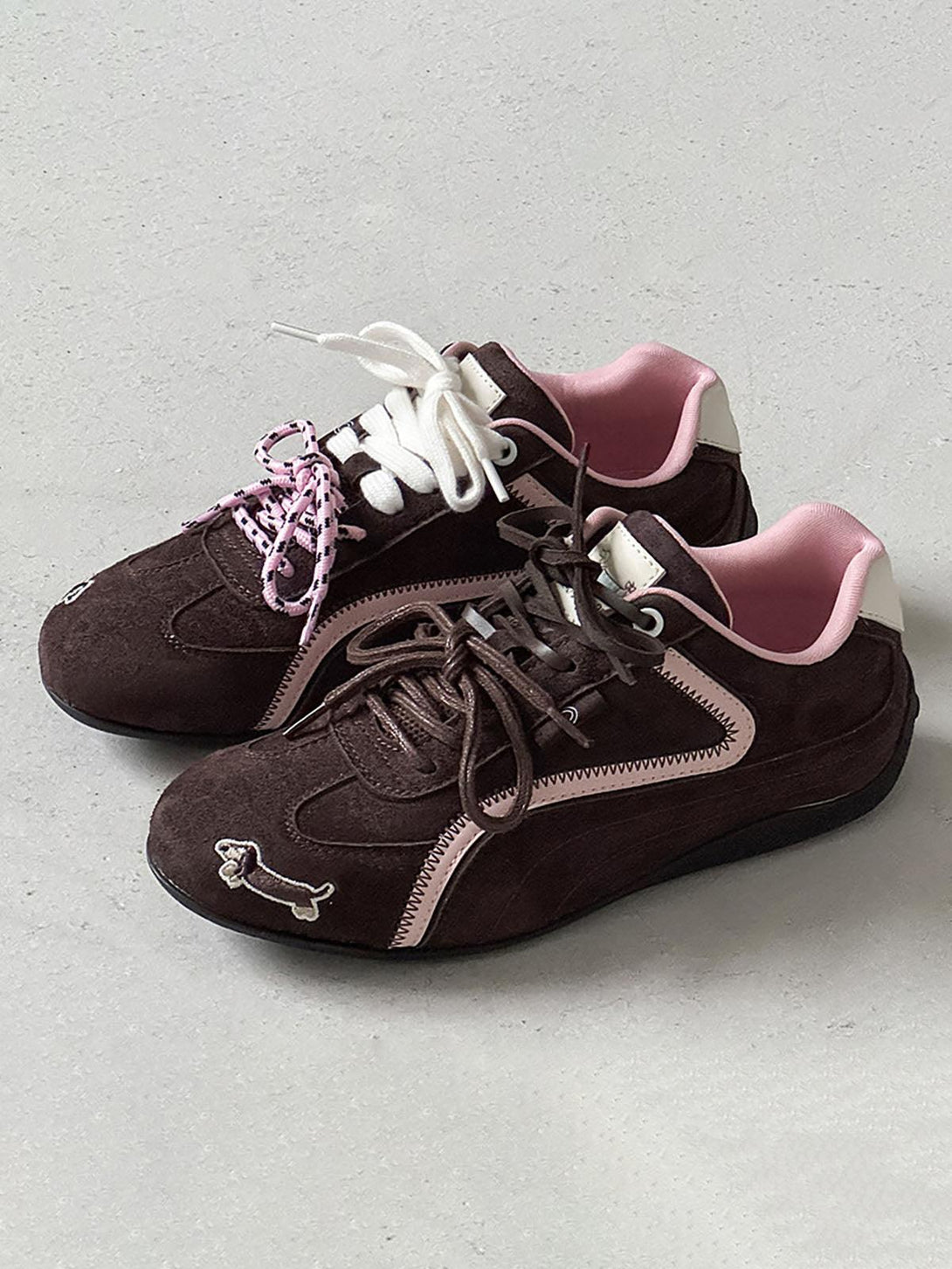 Brown suede lace-up sneakers by TALISHKO, featuring playful dog embroidery and mixed laces.