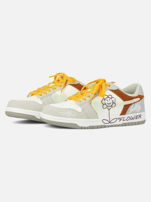 TALISHKO skate shoes in gray with vibrant yellow laces and playful flower design, front view.
