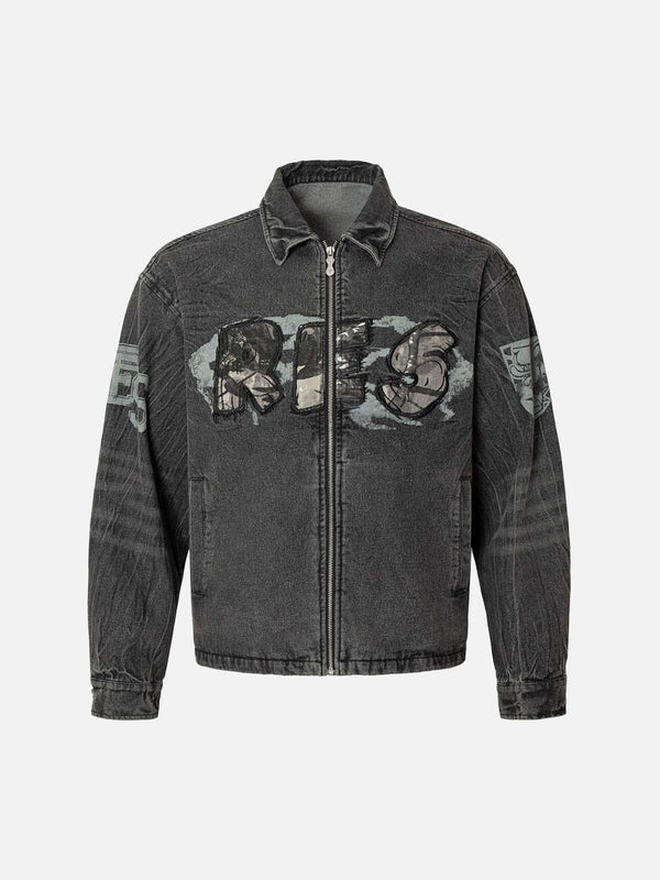 Front view of a black denim jacket by TALISHKO, featuring bold embroidery and a rugged street style.