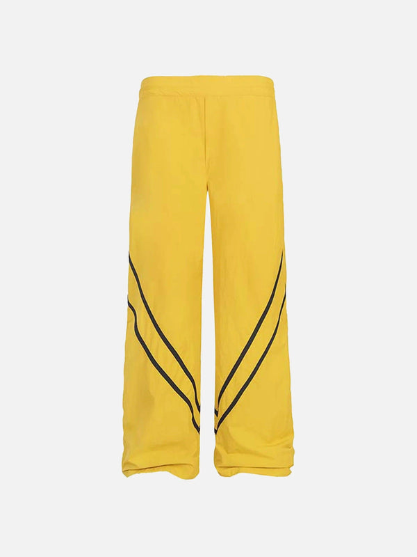 TALISHKO yellow sweatpants with black stripe detail, front view in a casual street style.