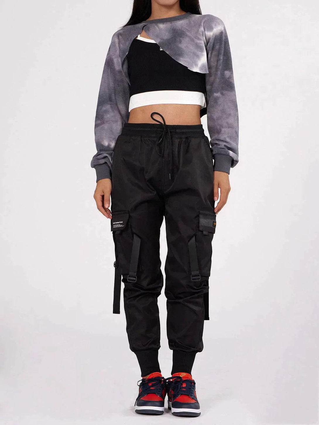 Model wearing TALISHKO tactical utility joggers with unique straps, paired with a cropped top.