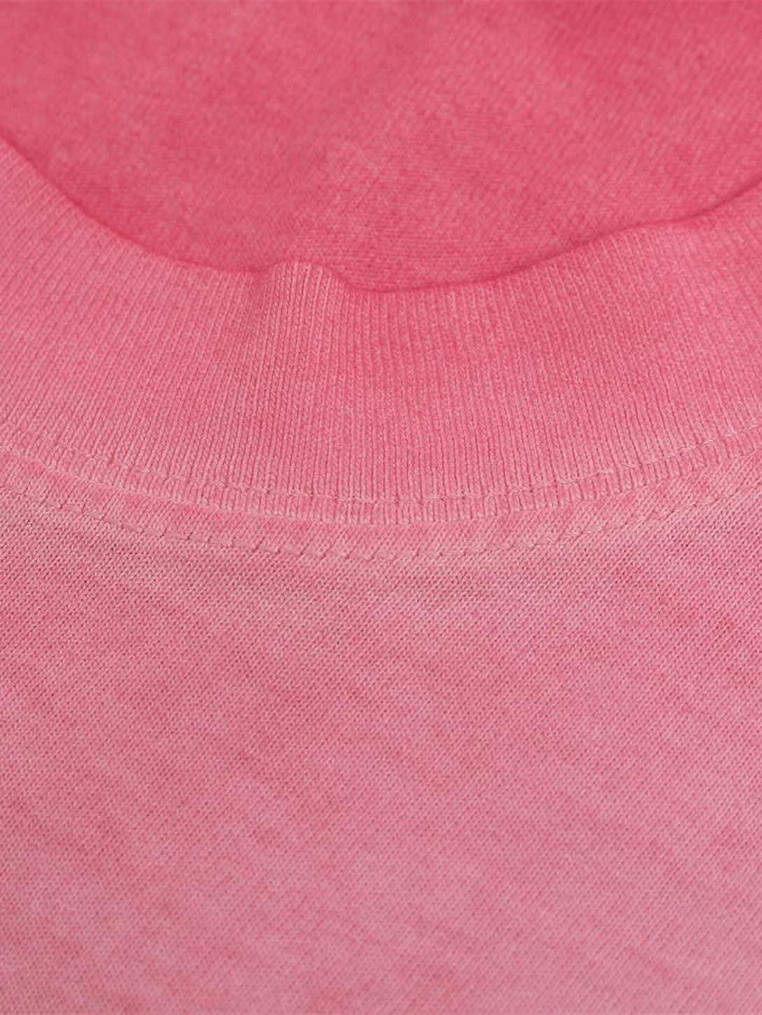 Zoomed-in texture of TALISHKO's pink graphic T-shirt, highlighting soft fabric details.