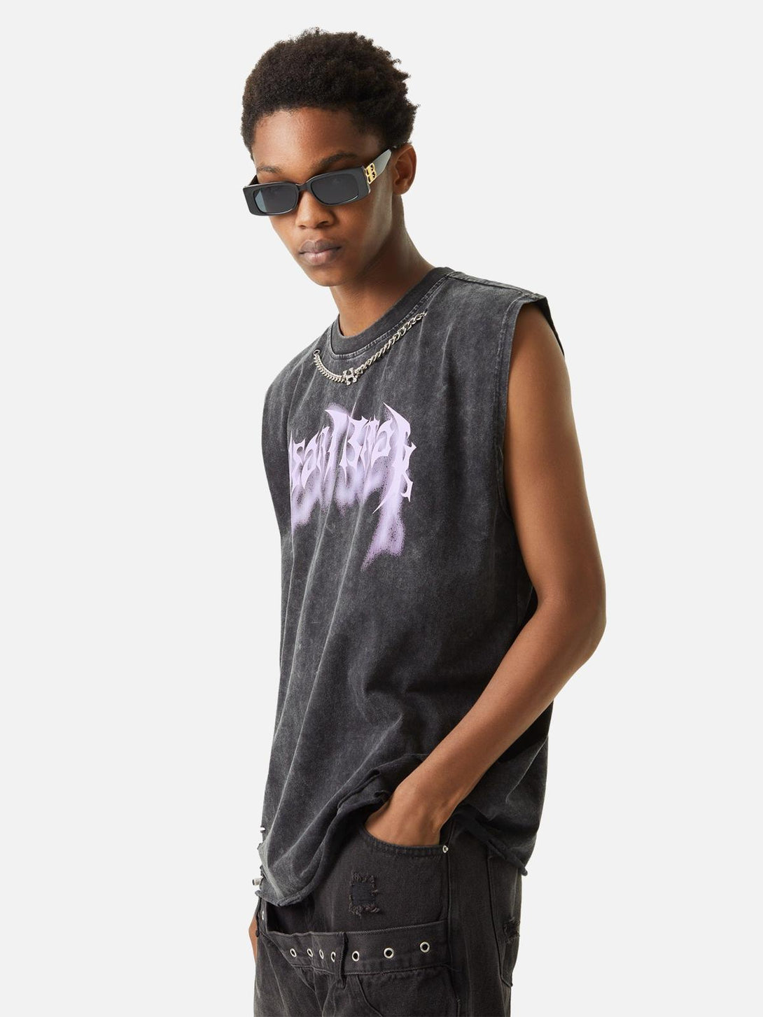Model wearing TALISHKO distressed vest with purple lettering and chain accents, exuding edgy style.