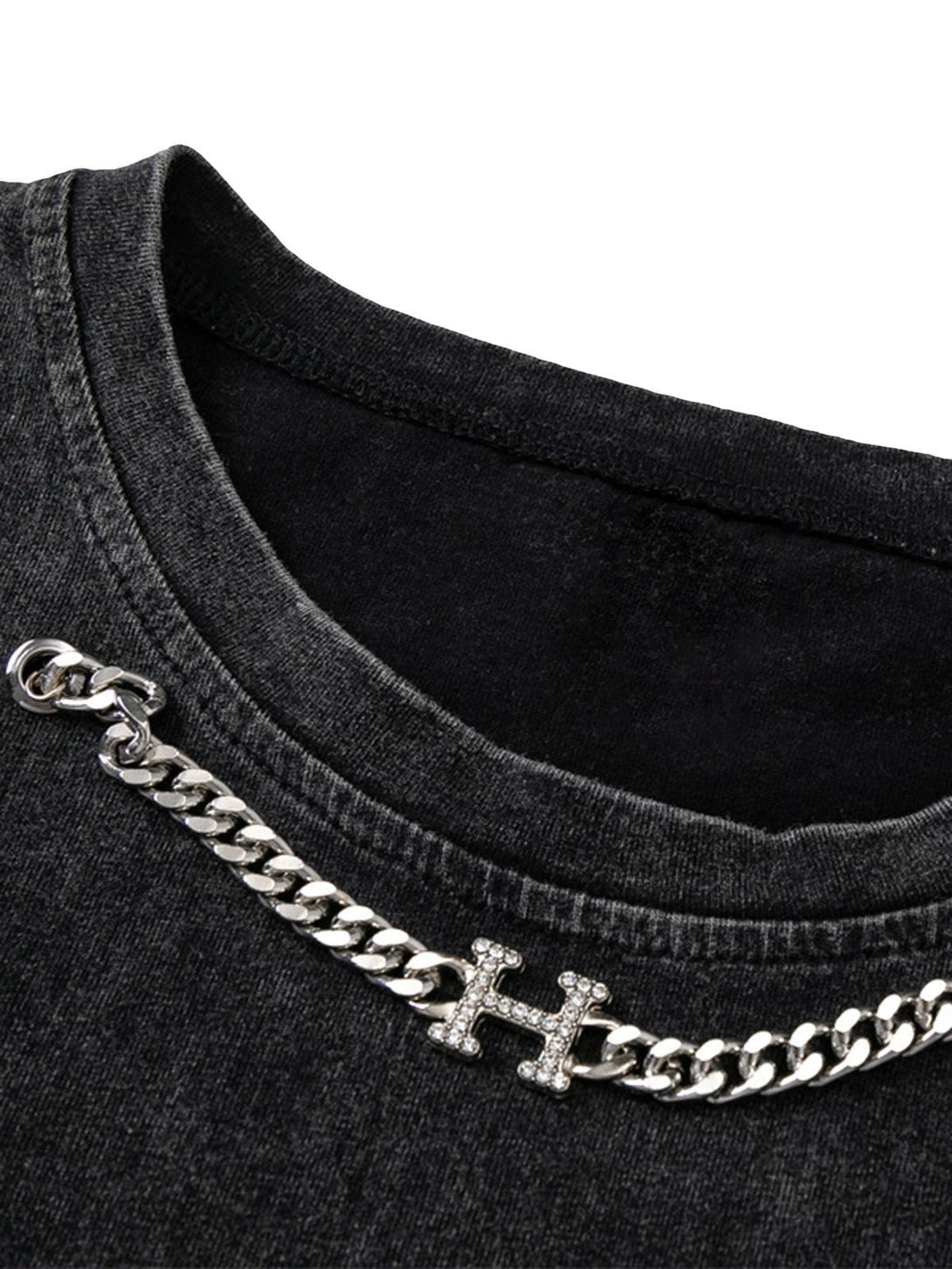 TALISHKO's distressed vest featuring a close-up of chain detail on washed black fabric.