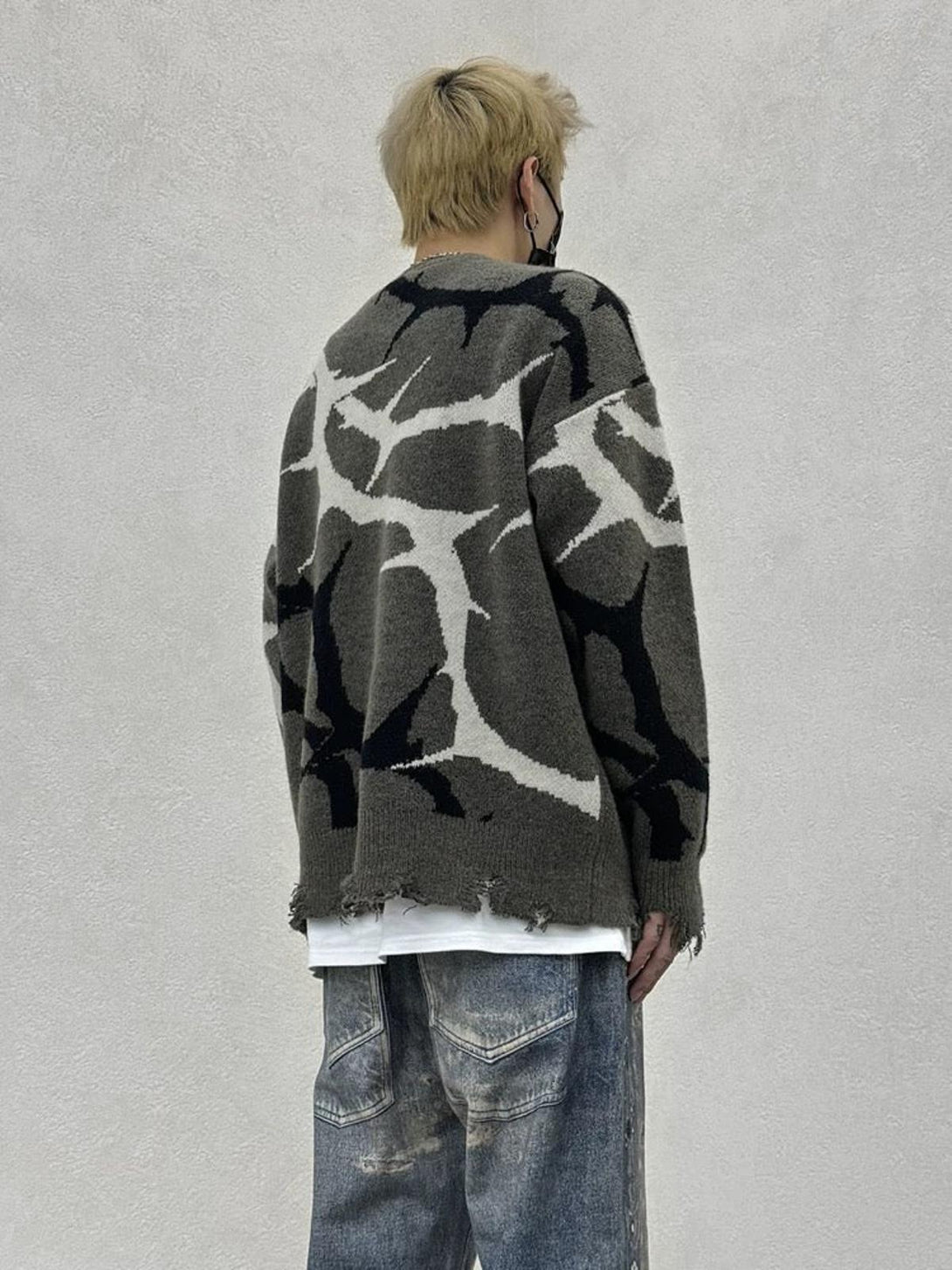 Back view of TALISHKO thorn-patterned sweater with distressed details and relaxed fit.