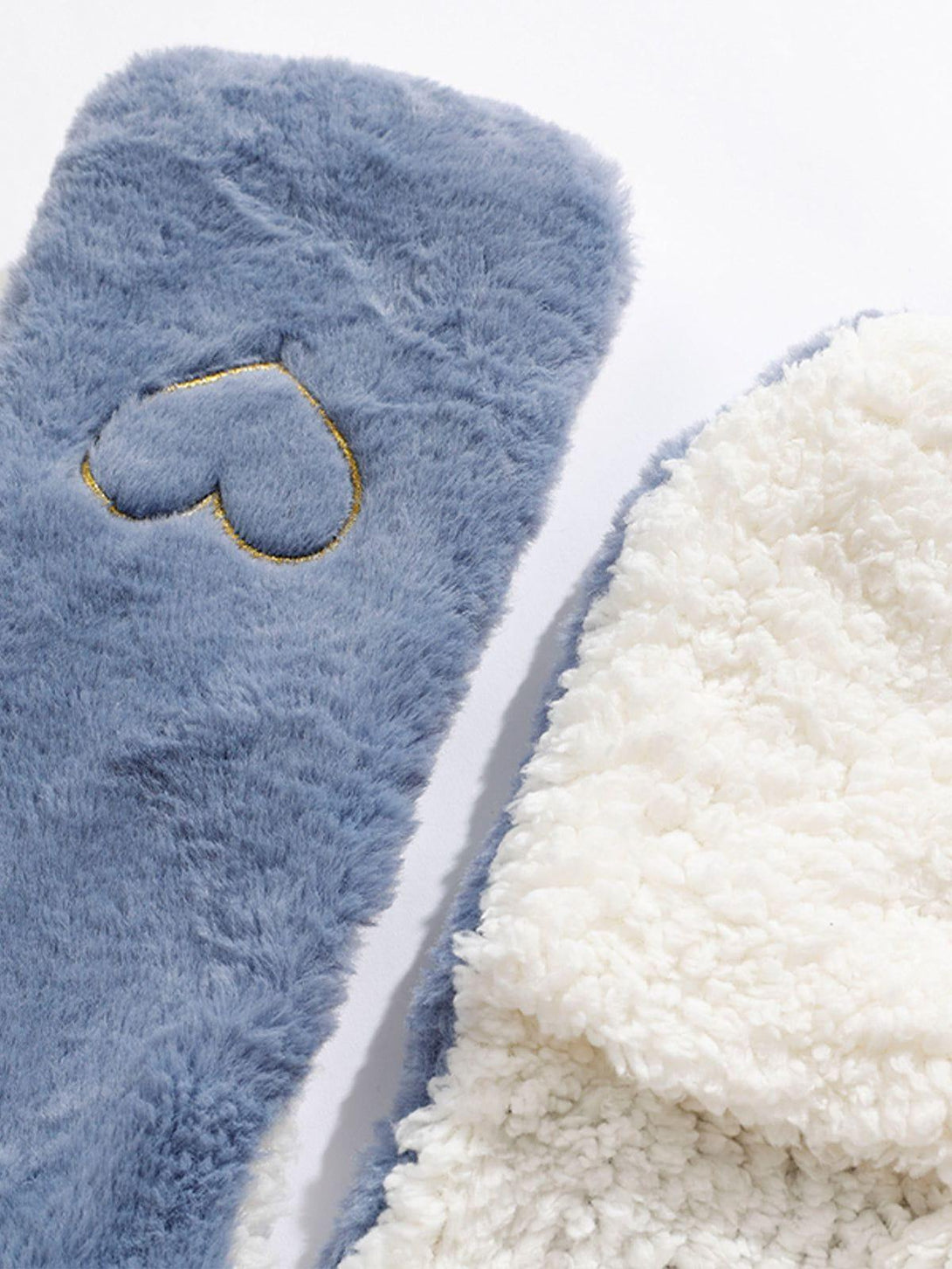 Focusing on the plush texture and heart detail of the blue and white TALISHKO winter accessory.