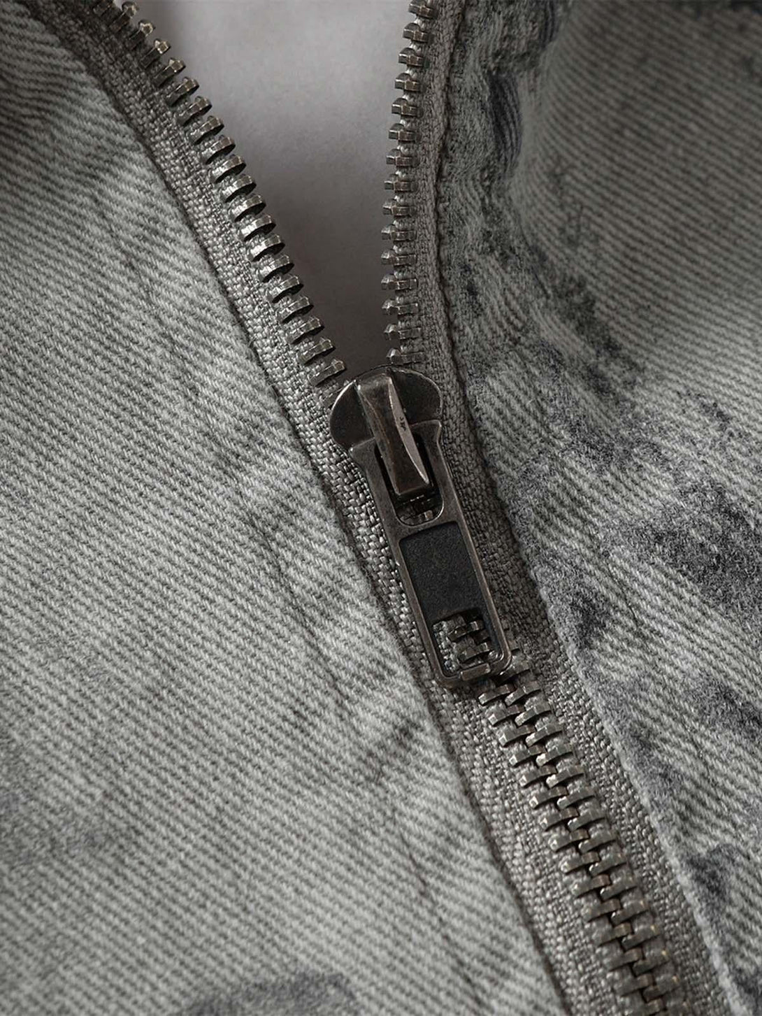 Intricate look at TALISHKO tie-dye denim bomber jacket zipper and texture detailing.